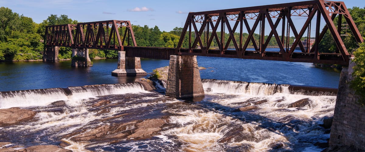 Ticonic Falls in Waterville, Maine, flows beneath the historic Two Cent Bridge, where the Kennebec and Sebasticook Rivers meet—once the heart of Teconnet, a vital Native American trading village