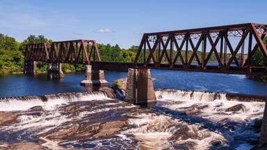 Ticonic Falls in Waterville, Maine, flows beneath the historic Two Cent Bridge, where the Kennebec and Sebasticook Rivers meet—once the heart of Teconnet, a vital Native American trading village