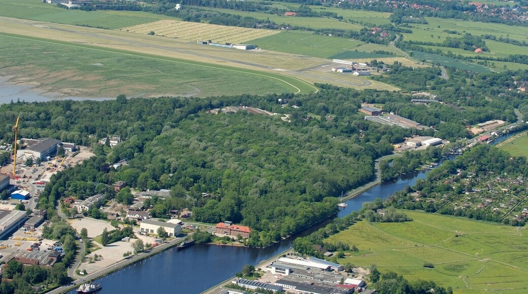 Fotoflug vom Flugplatz Nordholz-Spieka über Cuxhaven und Wilhelmshaven Im Vordergrund der Wilhelmshavener Kanalhafen am Ems-Jade-Kanal, am oberen Bildrand die Gemeinde Sande im Landkreis Friesland, dazwischen der JadeWeserAirport (ehemals Flugplatz Mariensiel).