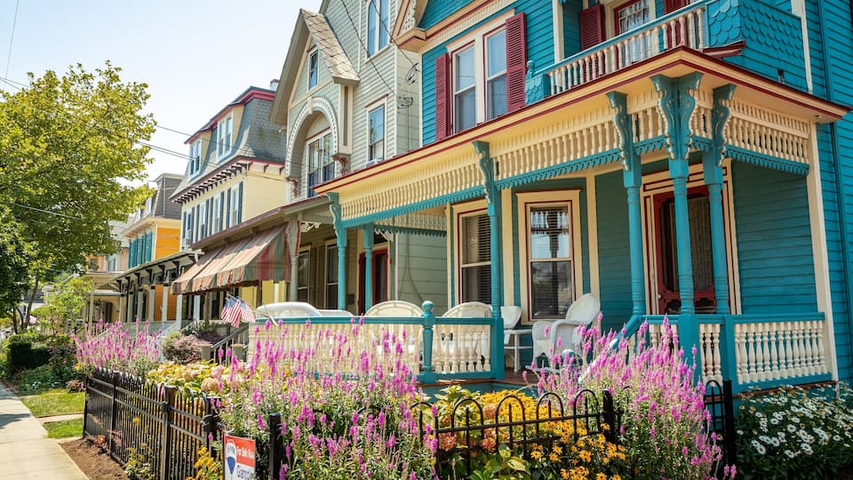 A row of colorful Victorian-style houses with a garden in front.