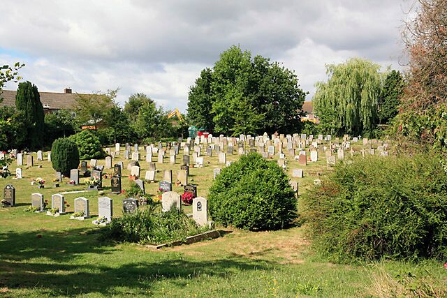 Graveyard of All Saints Church, Botley. The graveyard is behind the church. The JCB in the background is building some flats for rent in Mortimer Road.