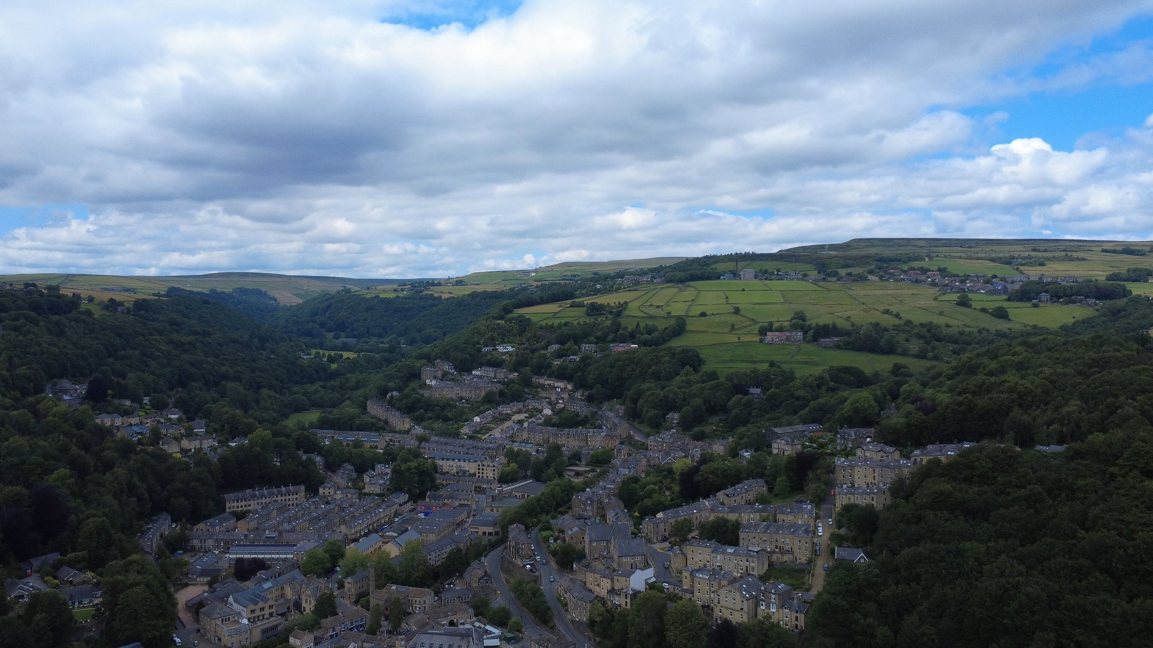 scenic aerial view of the town of hebden bridge town in summer surrounded by fields and trees