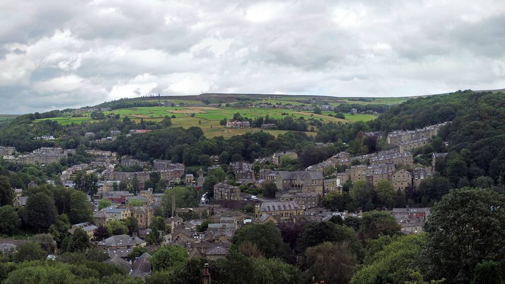 A town nestled in a valley with rolling hills in the background.