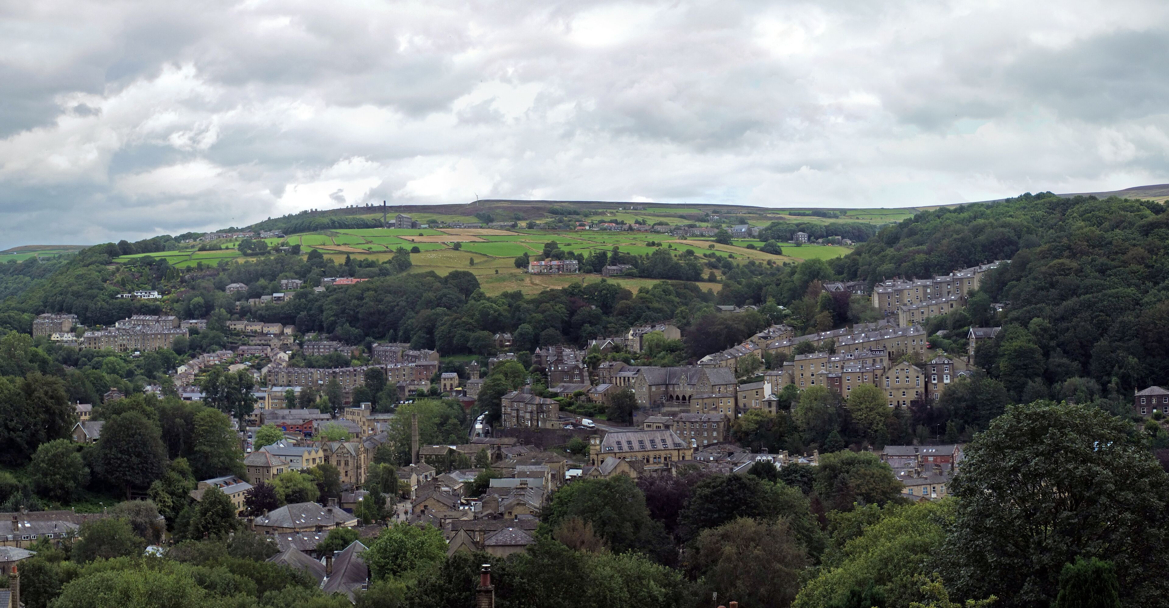 A town nestled in a valley with rolling hills in the background.