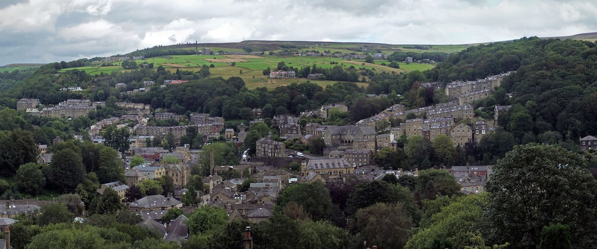 A town nestled in a valley with rolling hills in the background.