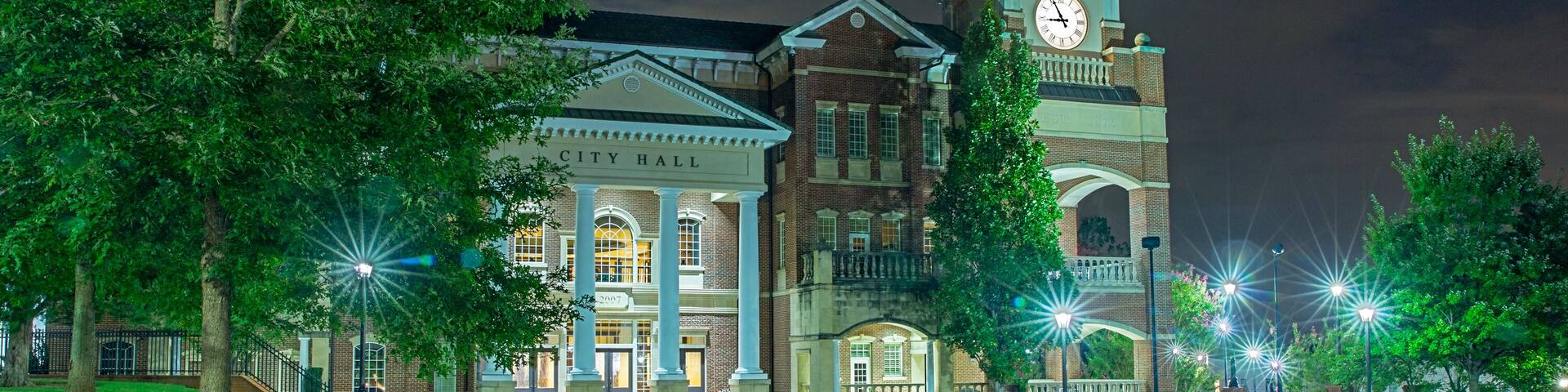 Small town parks just outside the big city are a great way to spend a Friday evening unwinding from the weekly stresses. A couple sit together enjoying the relaxing atmosphere while engaged in conversation. They huddle together as the warm day relinquishes its grasp to a cool evening.