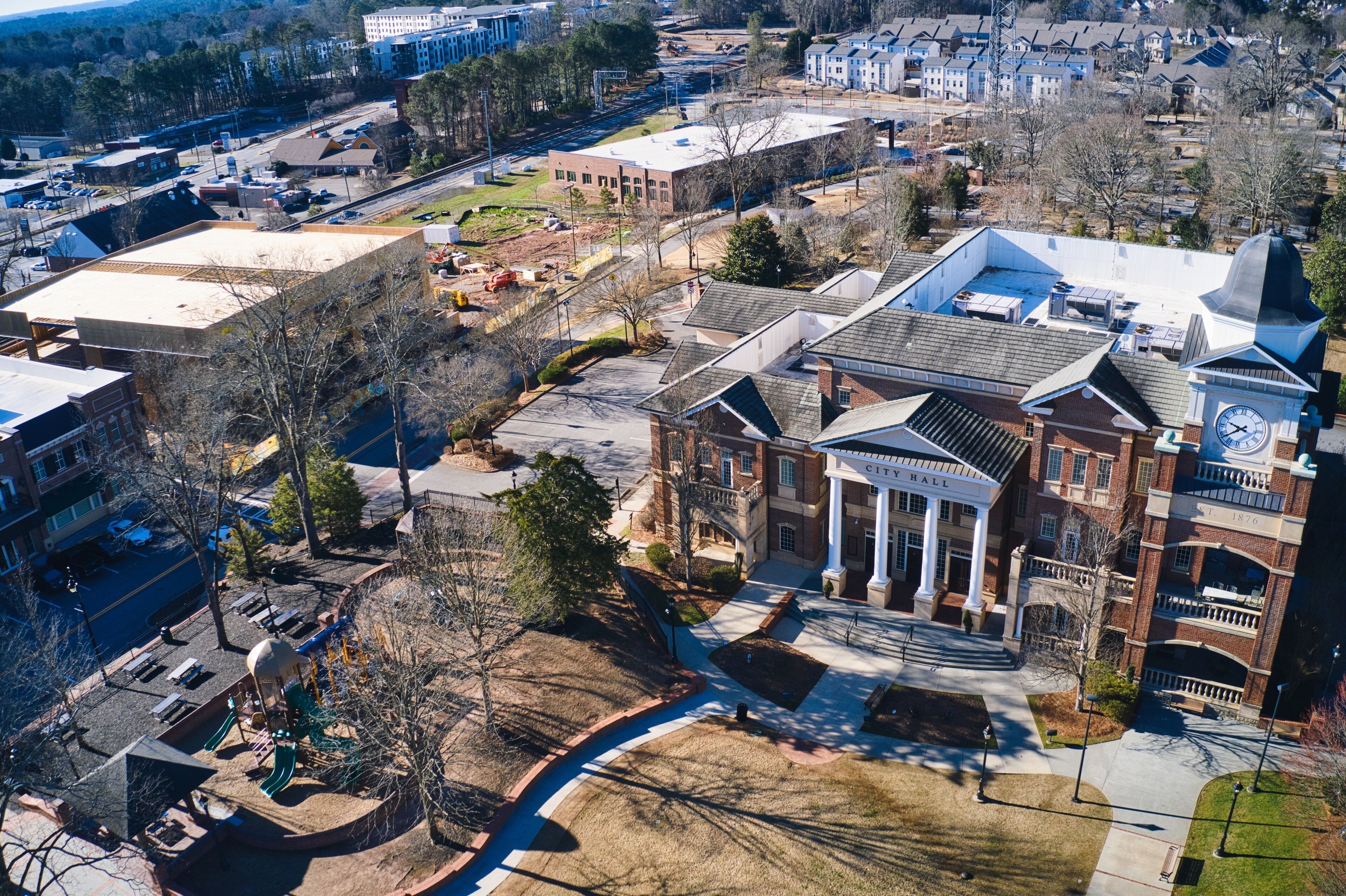 A large brick building with a clock tower and a playground.
