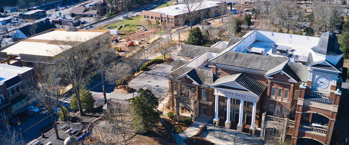 A large brick building with a clock tower and a playground.