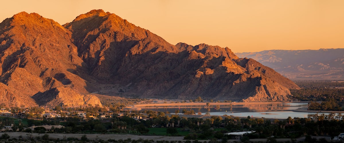 A mountainous landscape with a river and a bridge.