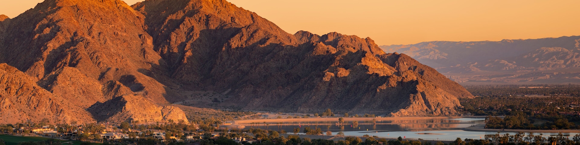 A mountainous landscape with a river and a bridge.
