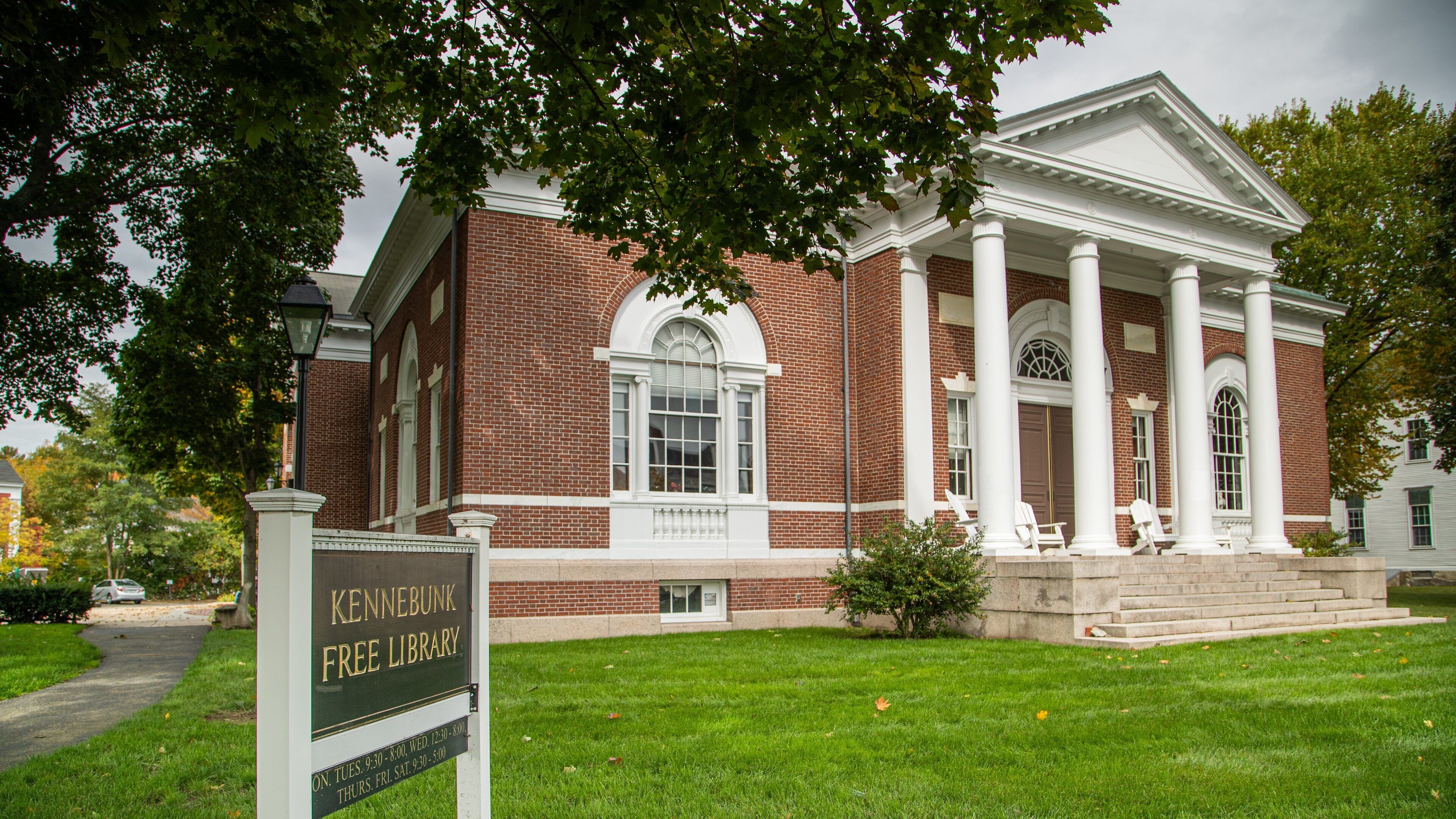 Un edificio de ladrillo con columnas blancas y un cartel que indica Kennebunk Free Library.