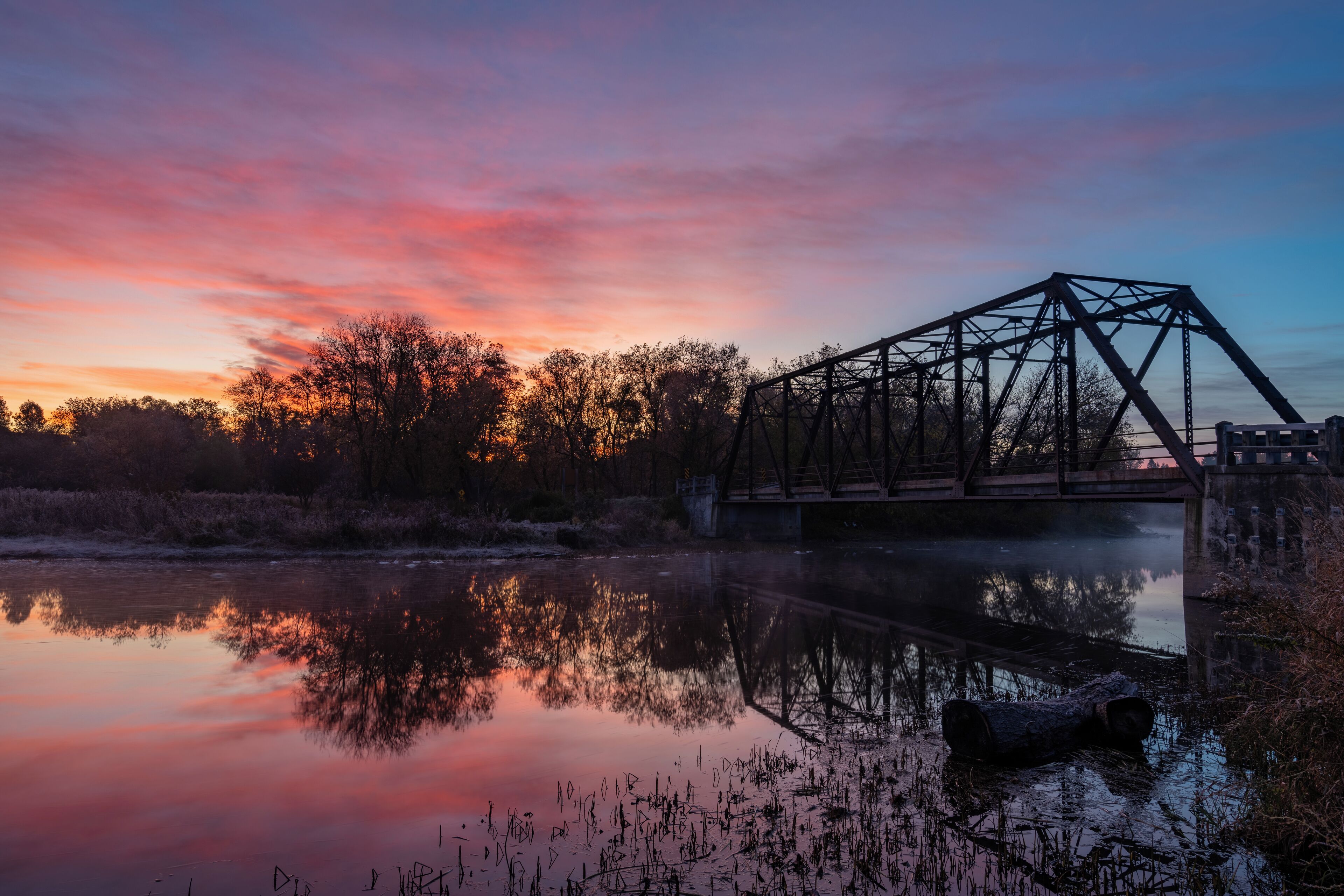 Sunrise at the steel truss black bridge constructed in 1916 in Cambridge, Ontario. 

I was driving the backroads instead of the highway one day to get to Guelph when I stumbled upon this hidden gem, an old single lane bridge.  I returned on the weekend for sunrise and got luckily with a great sunrise.

#Trovember