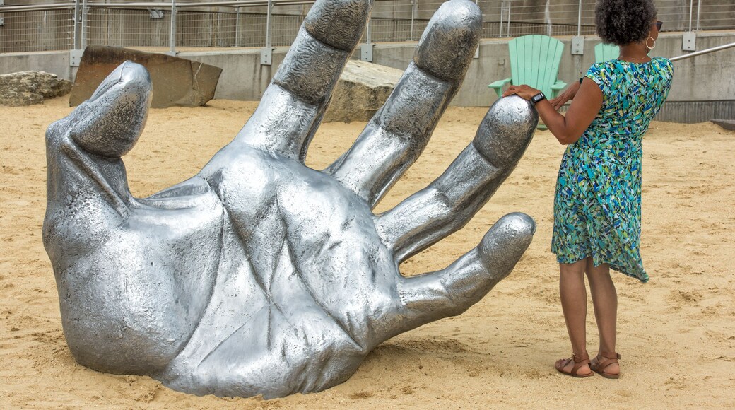 OXON HILL, MD - JUNE 19, 2015: Awakening Sculpture at National Harbor on August 24, 2013 at Oxon Hill, MD USA. A famous 70-foot statue of a giant embedded in the earth created by J. Seward Johnson Jr.