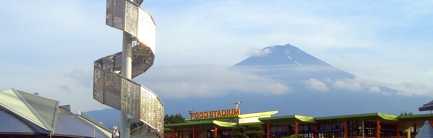 Una fuente en espiral, un espacio gastronómico y una montaña al fondo.