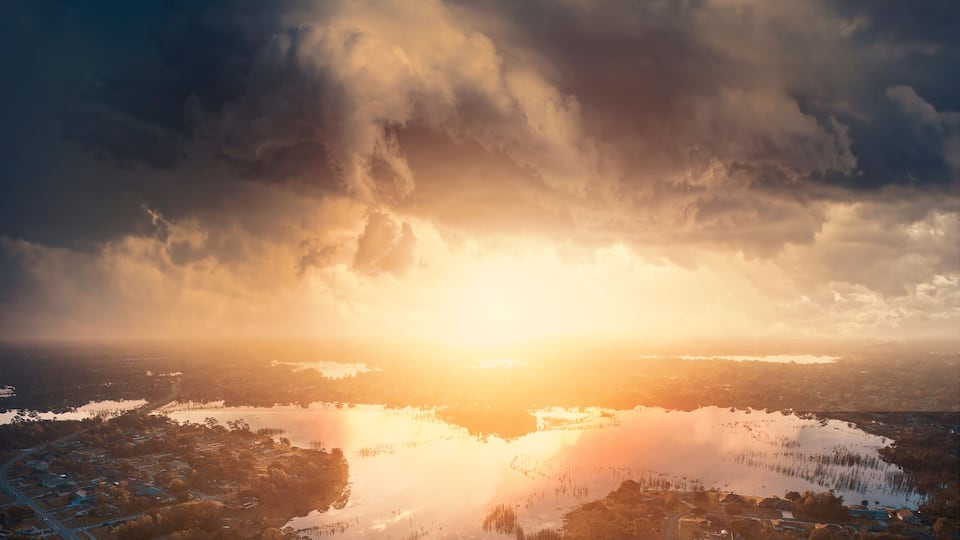 A sunset over a lake with a residential area in the foreground.