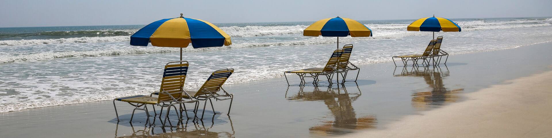 Colorful beach chairs and umbrellas sitting on the sand at Daytona Beach, Florida