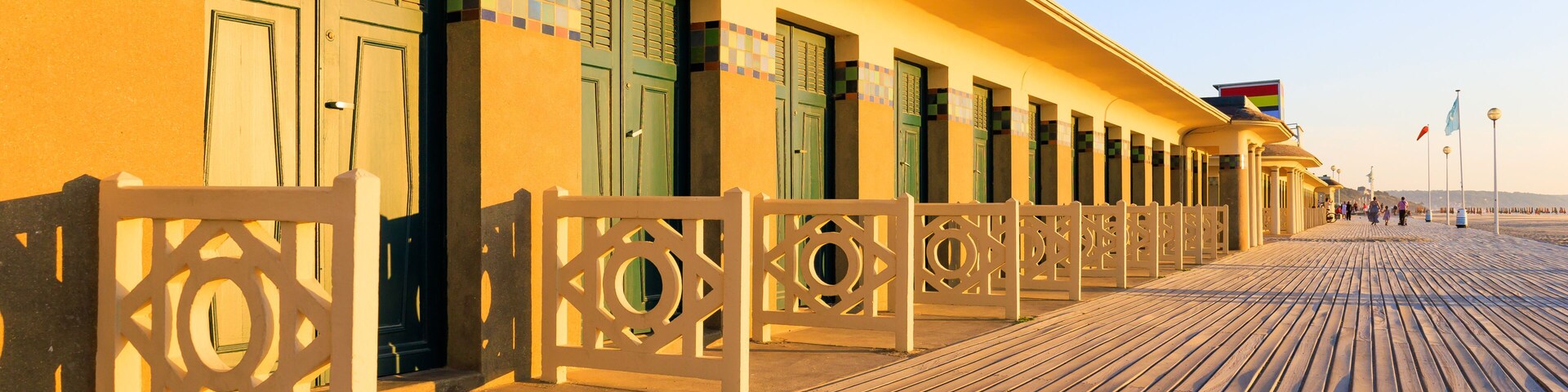 Um calçadão de madeira com portas e uma parede revestida de azulejos.