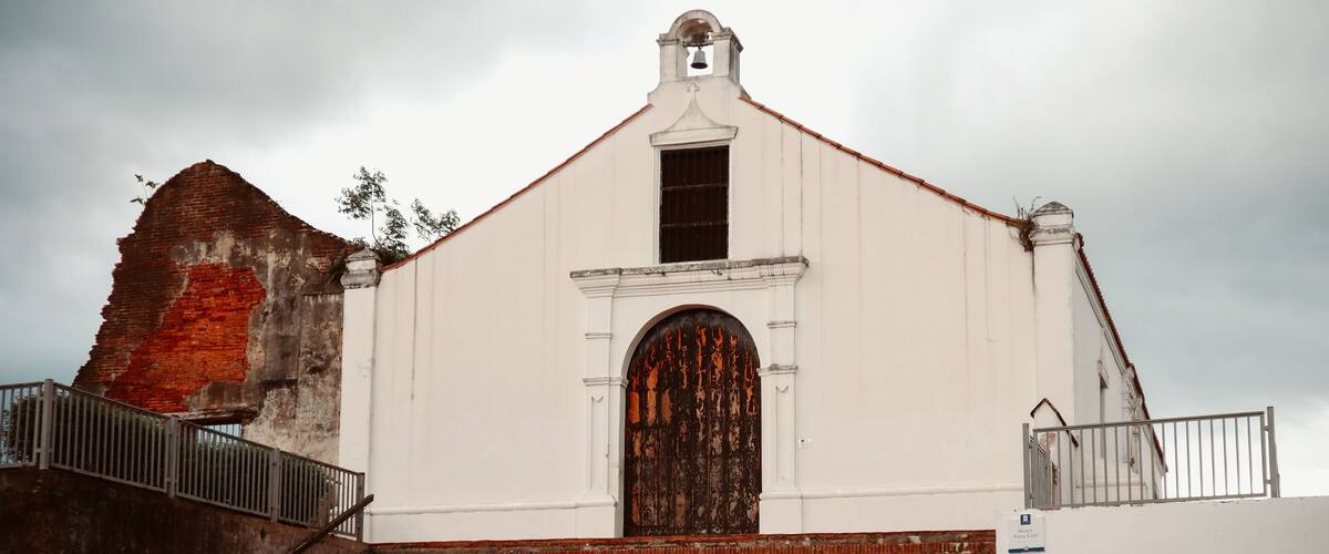 A white church with a bell tower and a large wooden door.