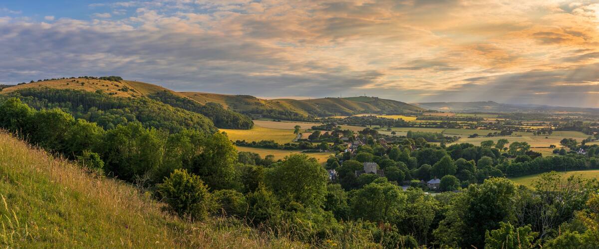 Rolling hills, a village, and a distant castle.