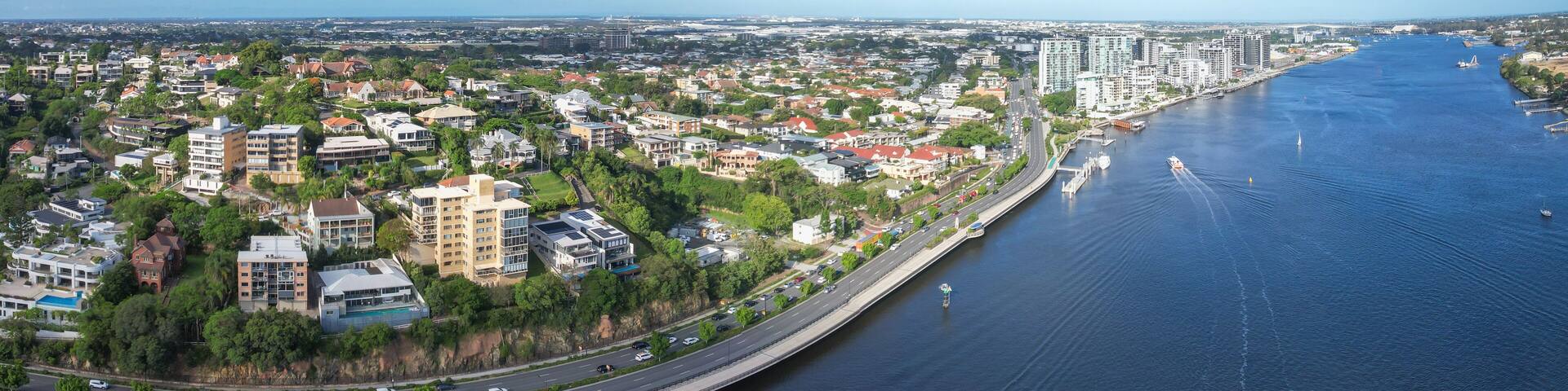 Aerial view of Portside Wharf along the Brisbane River with the Gateway Bridge and cityscape, Hamilton, Australia.