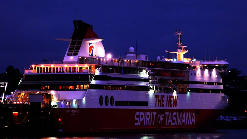 A large cruise ship named 'The New Spirit of Tasmania' docked at night.