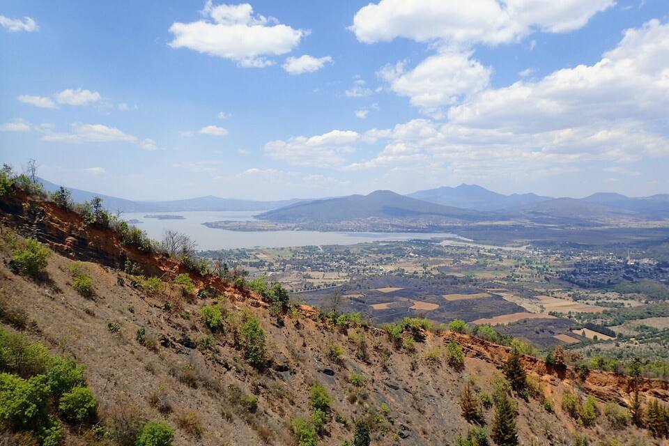 Un paysage montagneux comprenant une vallée, une rivière et des montagnes à l’horizon.