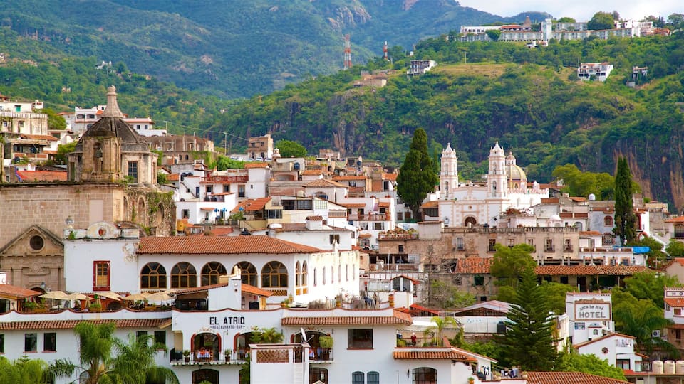 A hillside town with historic buildings, a prominent church, and a hotel.