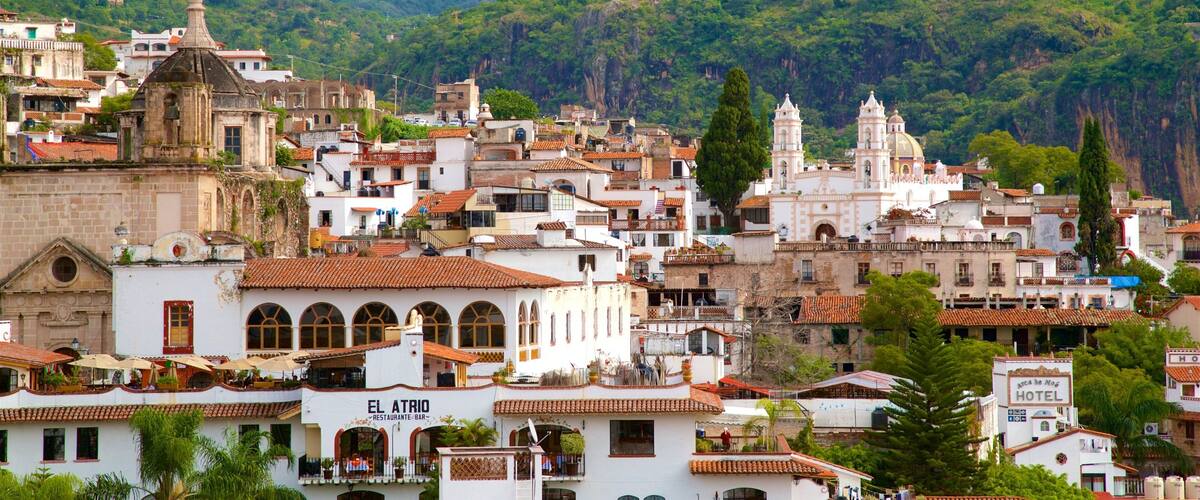 A hillside town with historic buildings, a prominent church, and a hotel.