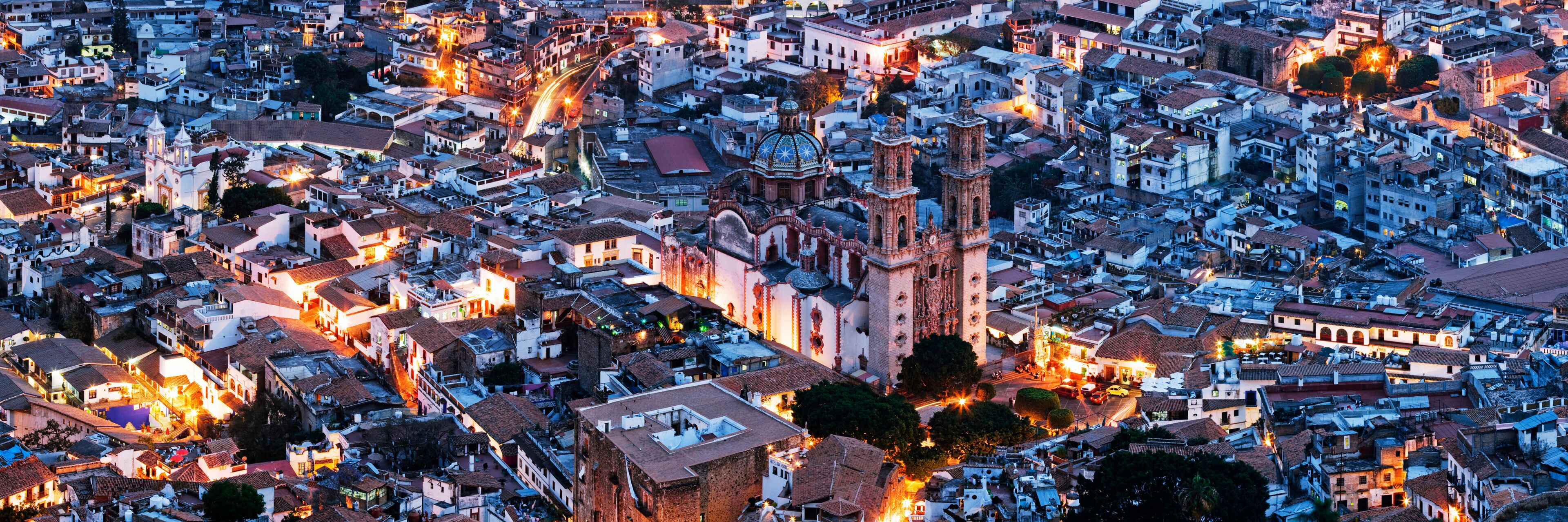A densely packed urban area with historic buildings, a prominent church with a dome, and a bell tower.