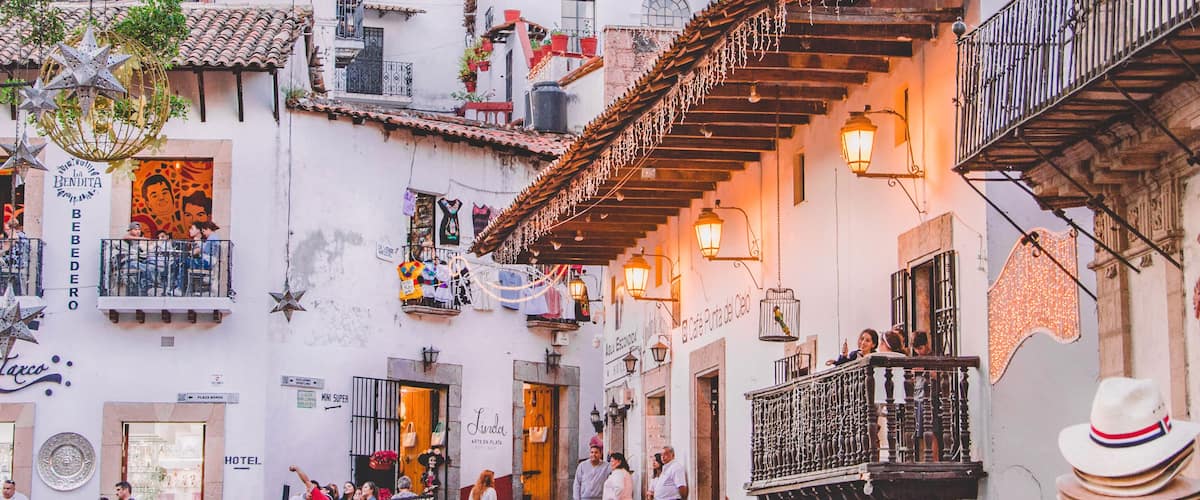 A bustling street with traditional buildings, a staircase, and people walking.