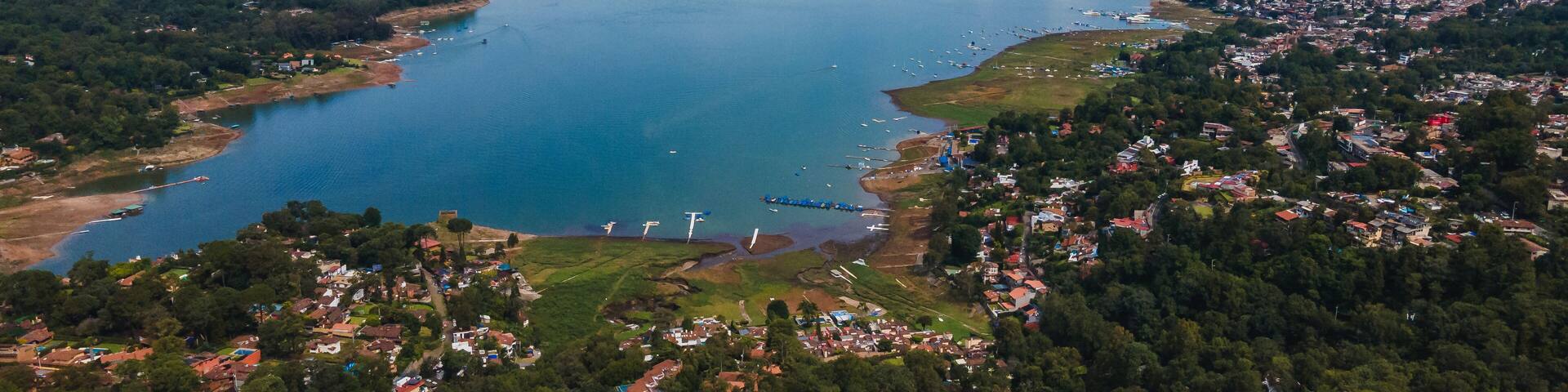 A coastal town with a large lake surrounded by mountains.