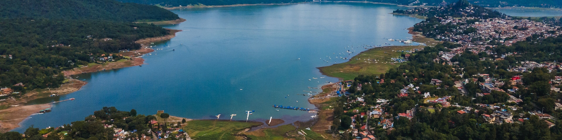 Uma cidade costeira com um lago grande rodeado por montanhas.