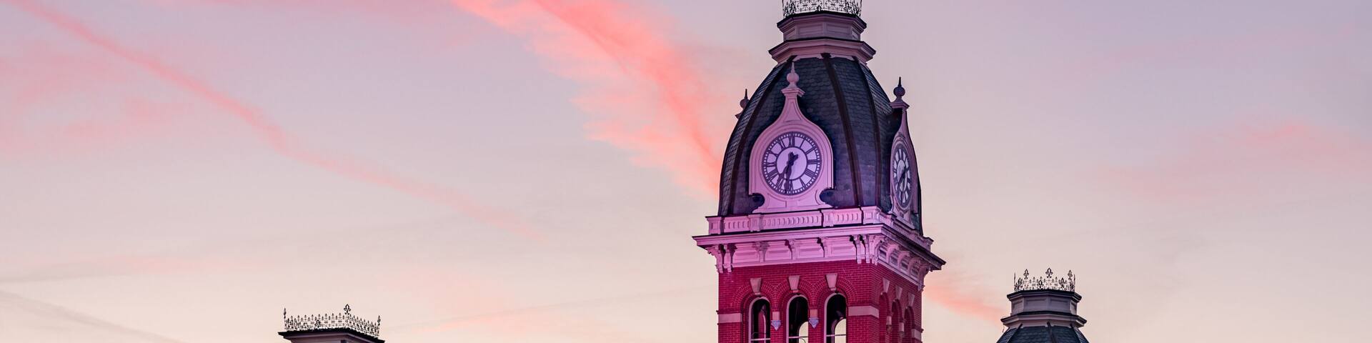 Dramatic image of Woodburn Hall at West Virginia University or WVU in Morgantown WV as the sun sets behind the illuminated historic building