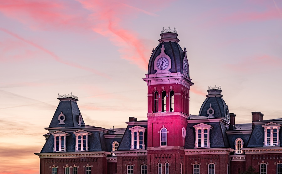 Dramatic image of Woodburn Hall at West Virginia University or WVU in Morgantown WV as the sun sets behind the illuminated historic building