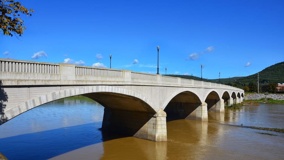 A stone bridge with multiple arches over a river.