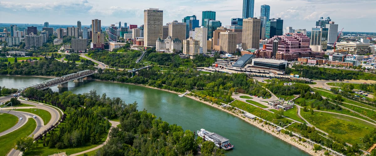 A city skyline with modern skyscrapers, a river, and a bridge.