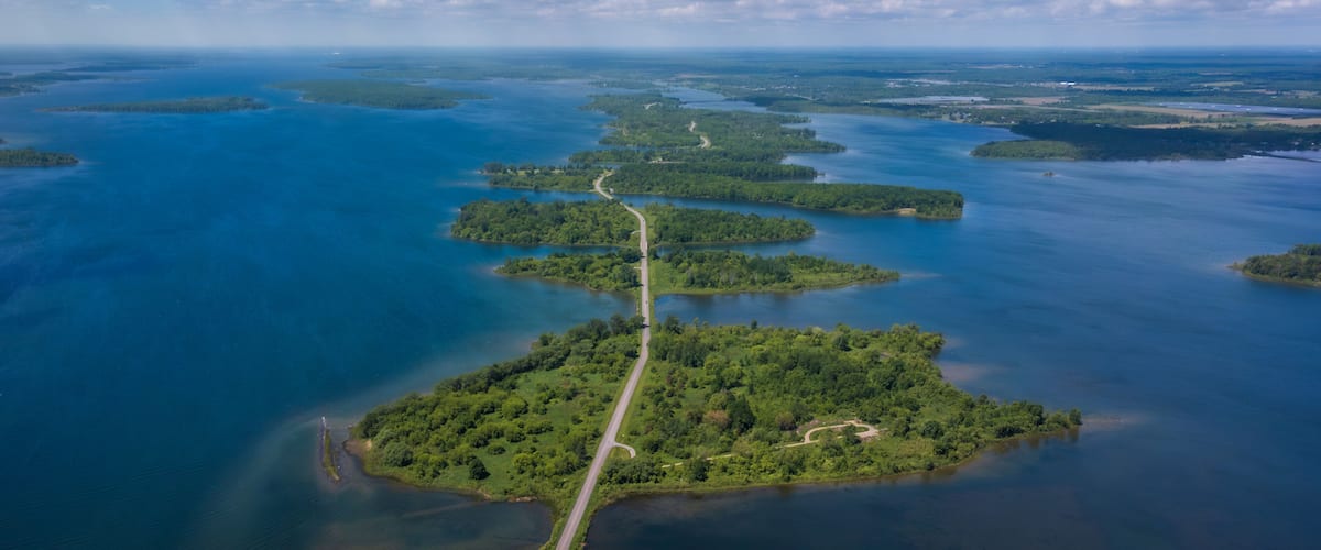 Aerial photo of Long Sault Parkway scenic route crossing Thousand Islands archipelago in the Saint Lawrence River near Cornwall, South Stormont, Ontario, Canada. Photo taken by drone in June 2022.