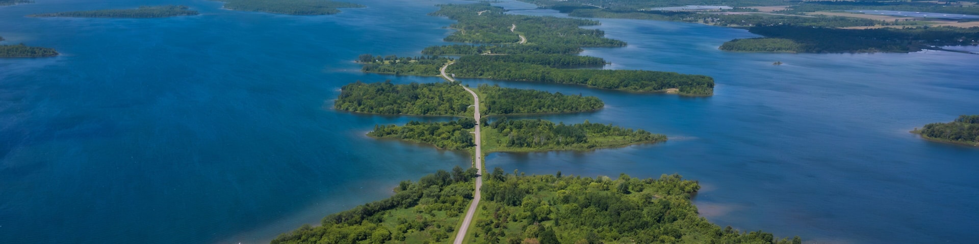 Aerial photo of Long Sault Parkway scenic route crossing Thousand Islands archipelago in the Saint Lawrence River near Cornwall, South Stormont, Ontario, Canada. Photo taken by drone in June 2022.