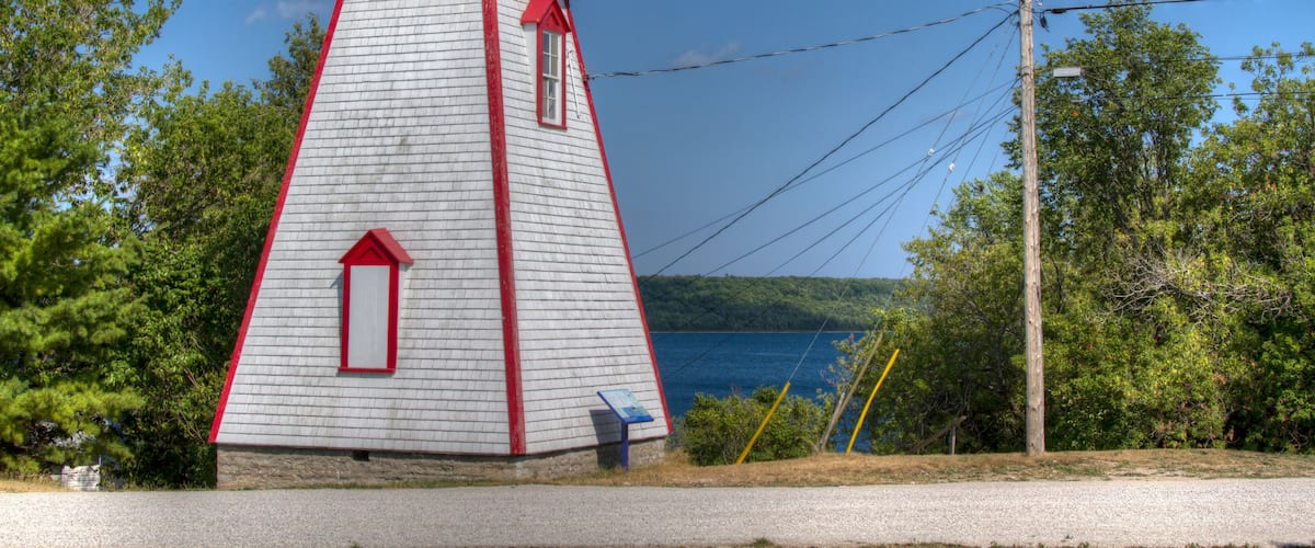 A red and white lighthouse with a clear view of the surrounding landscape.