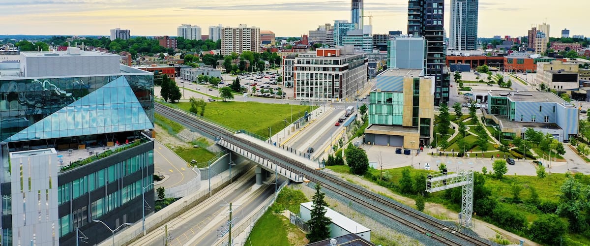 A cityscape with modern buildings, a bridge, and a railway track.