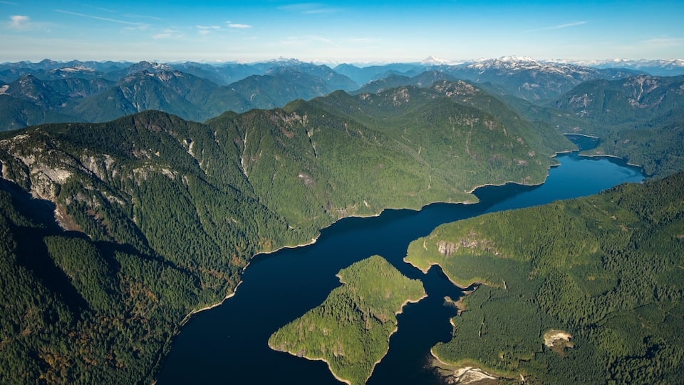 A mountainous landscape with a winding river and a lake.