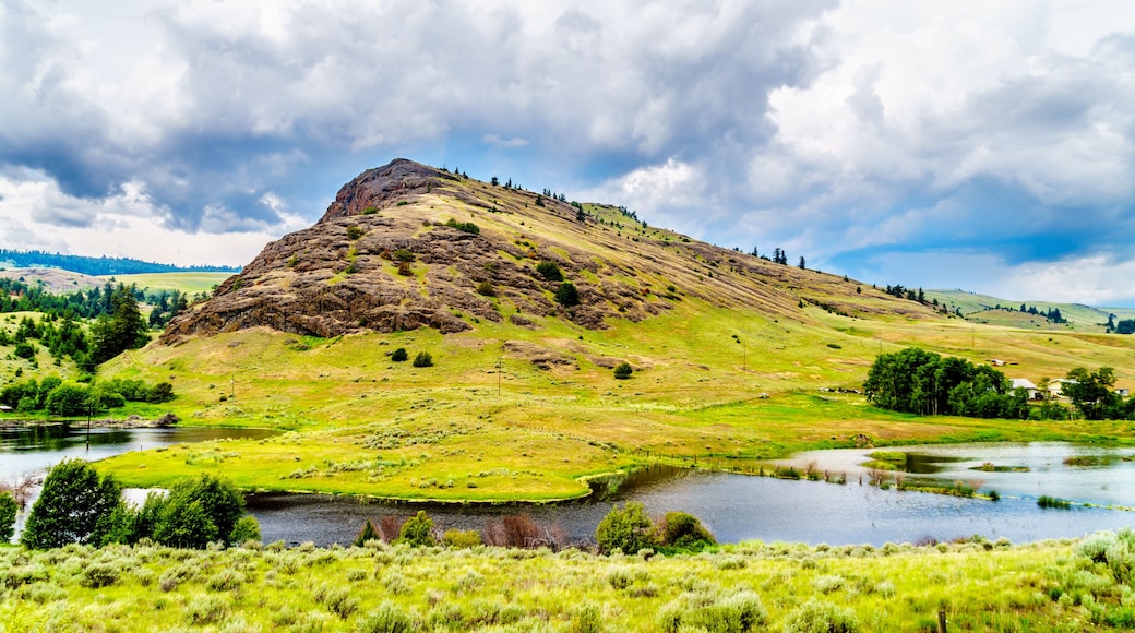 Rocky Mountain among the rolling hills in the Nicola Valley along Highway 5A between Merritt and Kamloops, British Columbia, Canada under dark cloudy skies