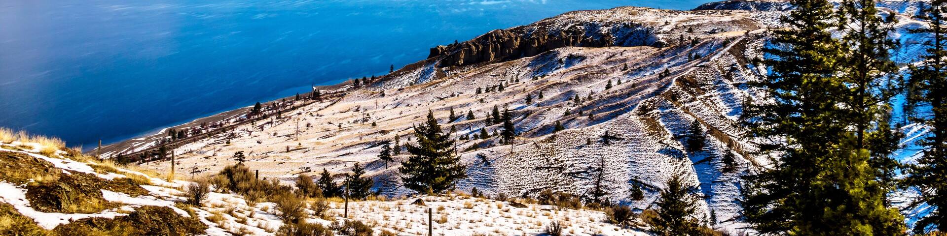 Snow Covered Mountains surrounding Kamloops Lake in central British Columbia, Canada on a cold and crisp Winter Day under a blue sky
