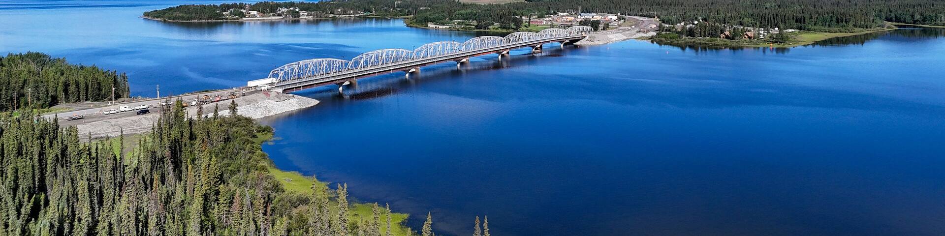 Discover stunning bridge crossing tranquil lake surrounded by lush green forests