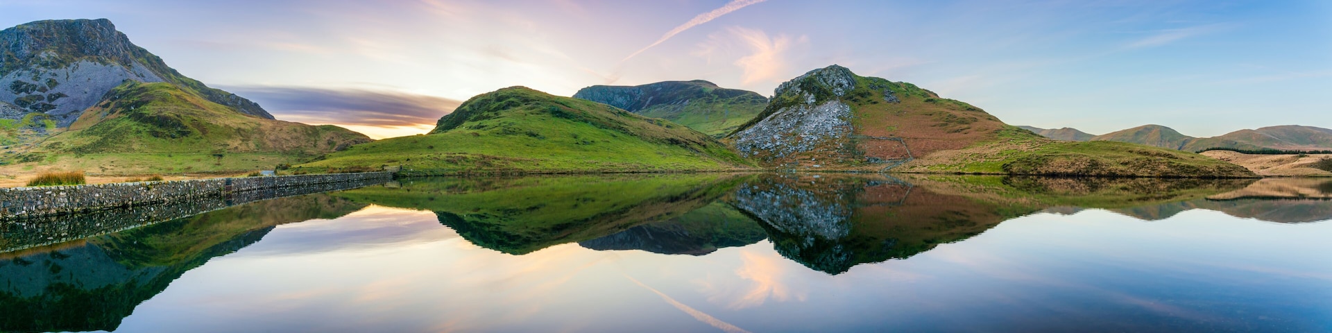 Paisagem montanhosa com um lago tranquilo refletindo a paisagem.