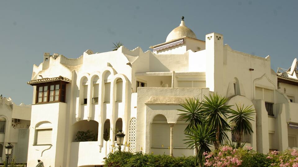 A white building with arches and a dome.