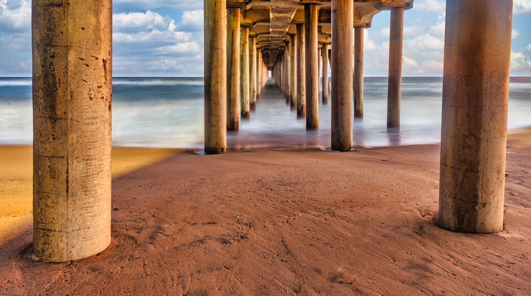 Long exposure captures slow moving waves under the Huntington Beach Pier in Huntington Beach, California