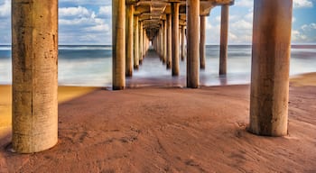 Long exposure captures slow moving waves under the Huntington Beach Pier in Huntington Beach, California