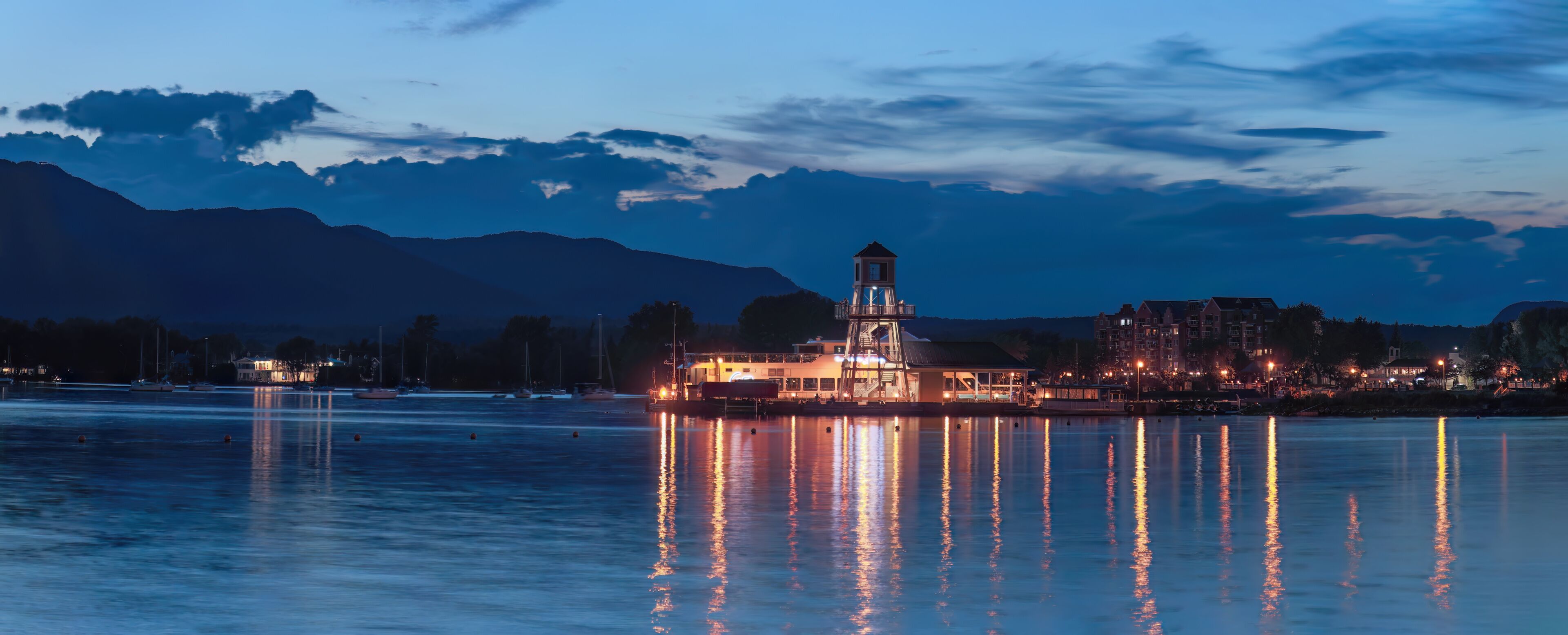 Magog harbor dock and lighthouse at night Memphremagog lake sunset light water and sky