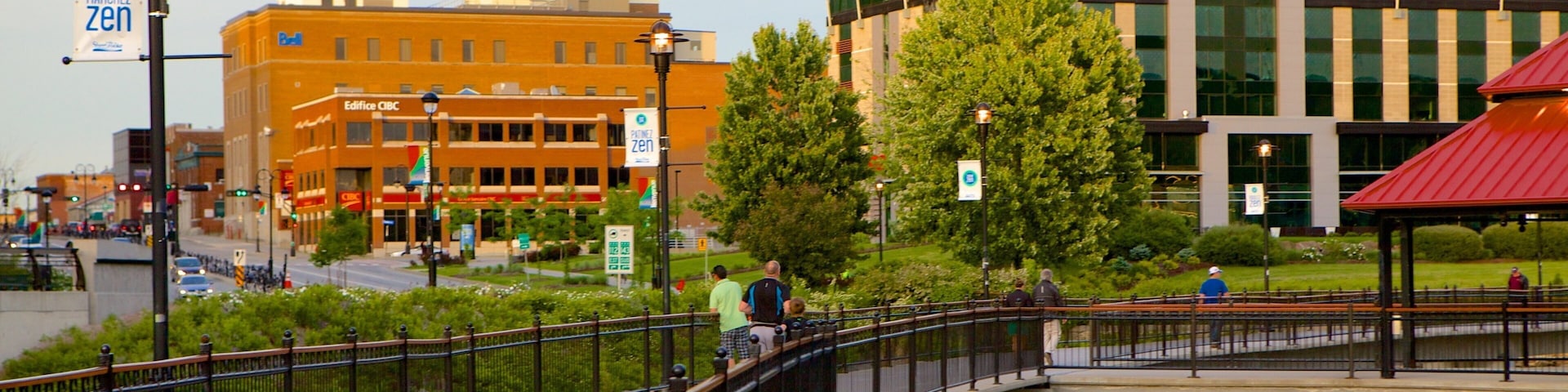 A pedestrian bridge over a canal with buildings, including a Times building, in the background.